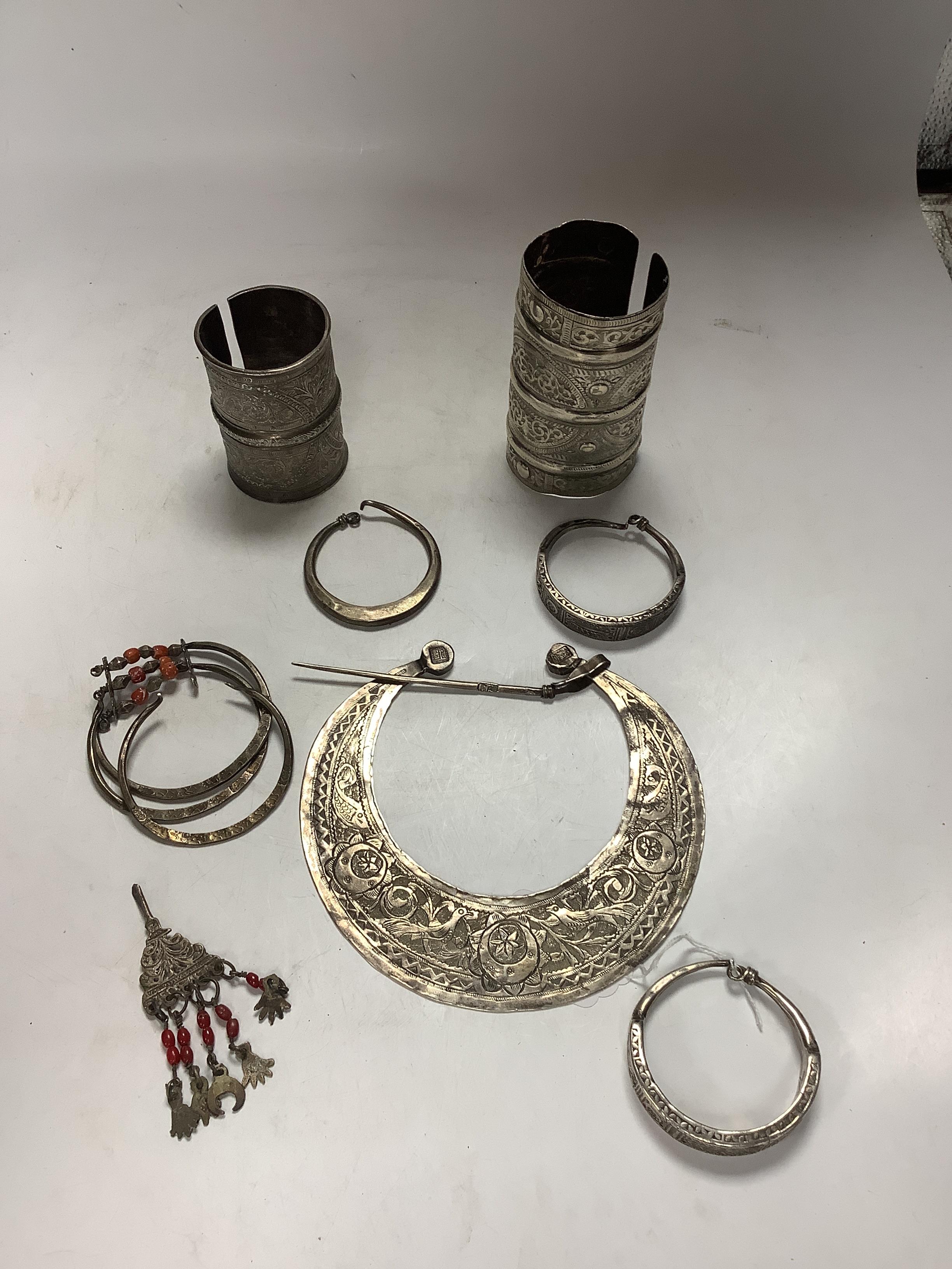 A collection of eight North African Berber white metal jewellery, etc, including bangles, cuffs and hair ornament.